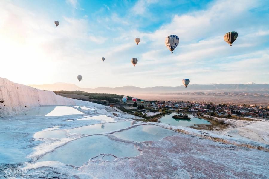 Balony nad trawertynami Pamukkale o wschodzie słońca