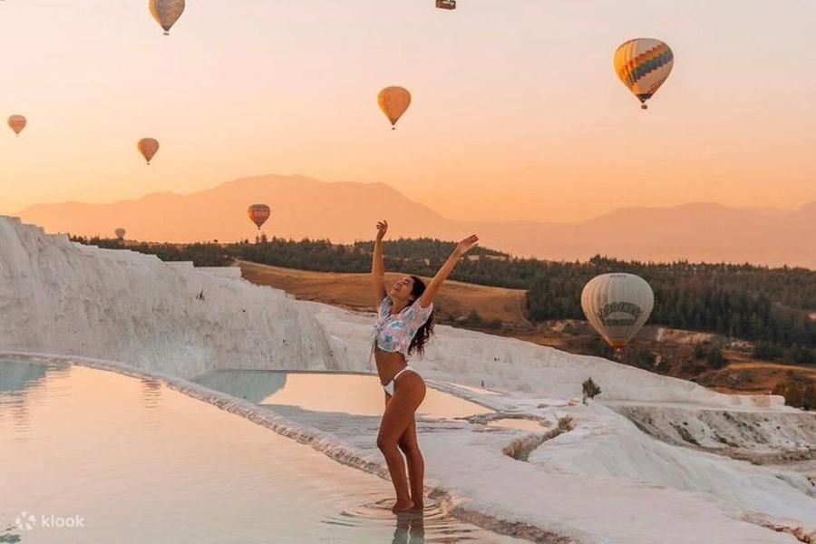 Balon na ogrzane powietrze nad ruinami Hierapolis i tarasami Pamukkale