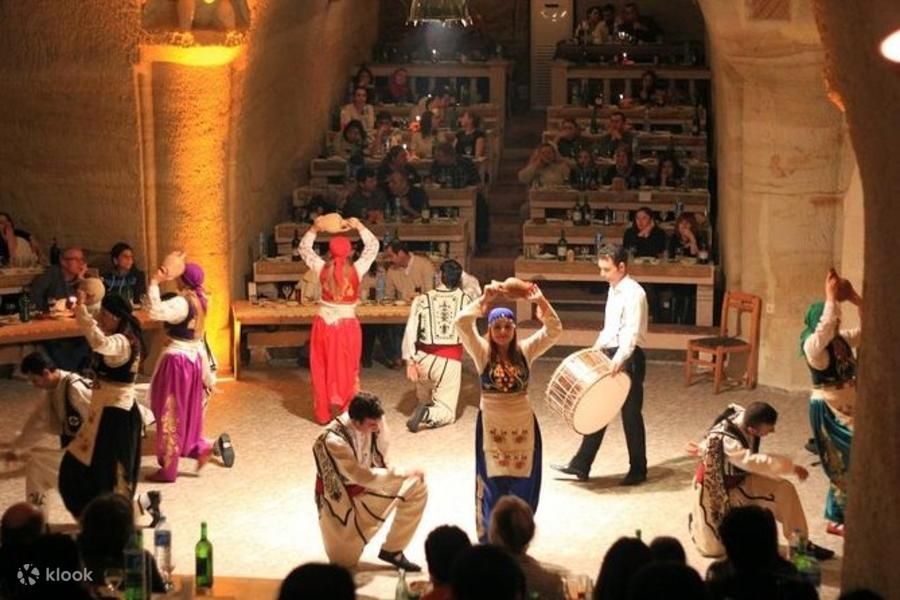 Tancerze w tradycyjnych strojach podczas wieczoru tureckiego w skalnej restauracji w Kapadocji
