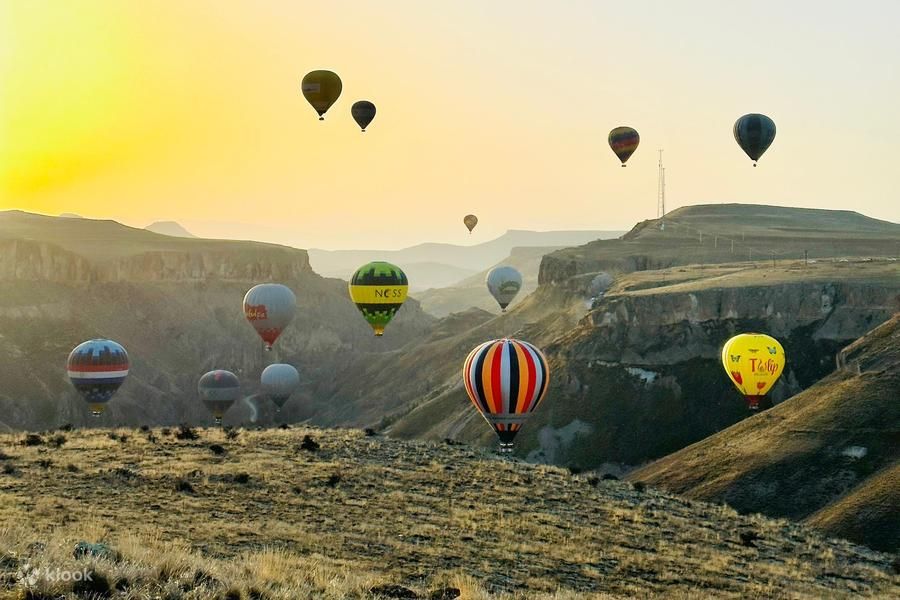 Kolorowe balony nad Doliną Soğanlı w Kapadocji o wschodzie słońca