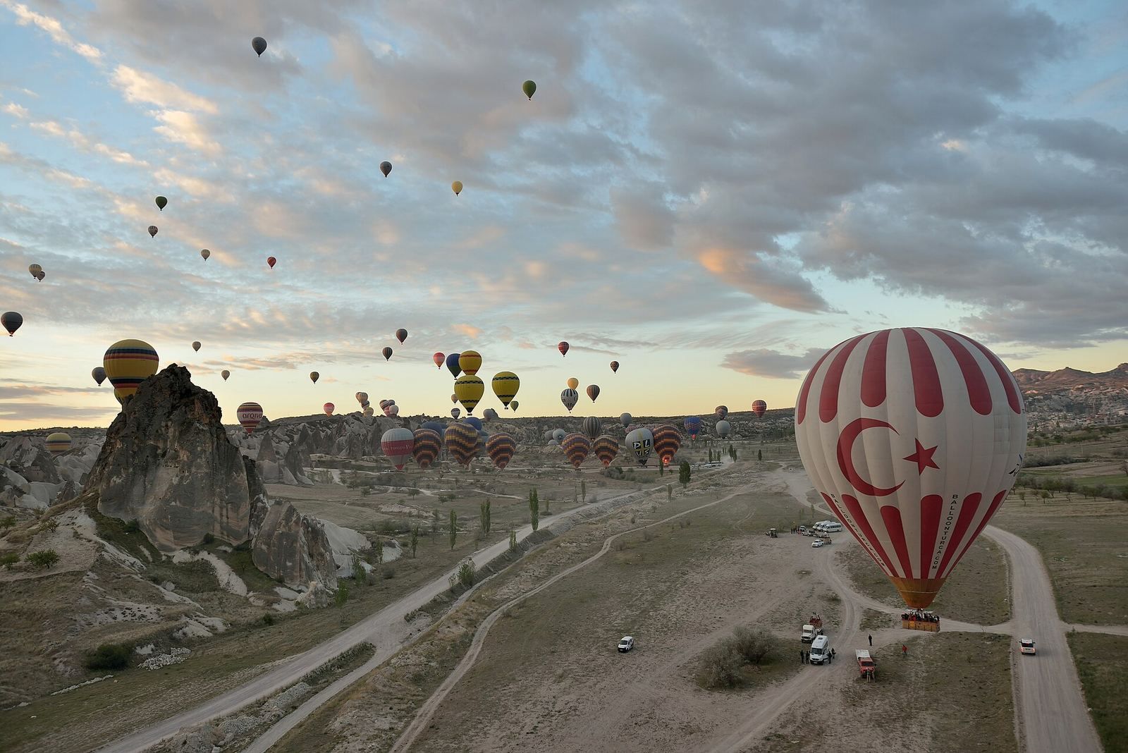 Masowy start balonów o świcie nad Kapadocją, podobny do porannych pokazów w czasie festiwalu balonów